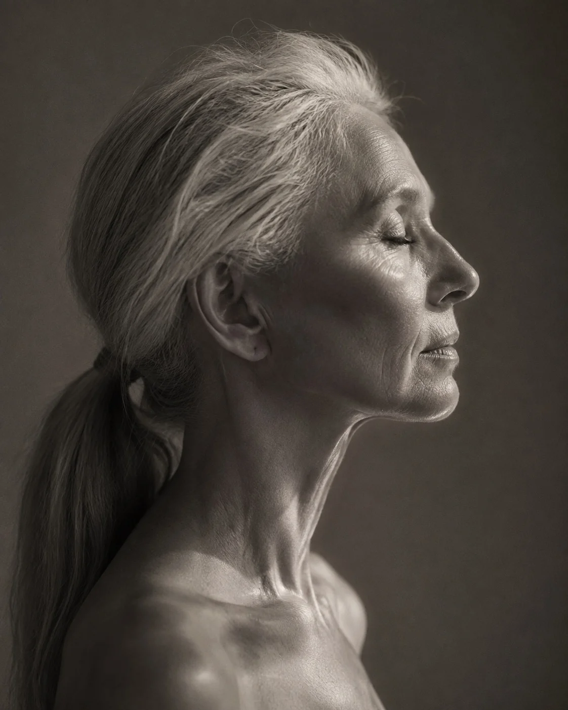 Monochrome profile study, hard lateral light rimming the jaw and cheekbone.